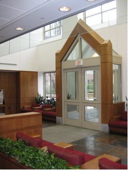 A lobby with a large glass door and wooden trim.